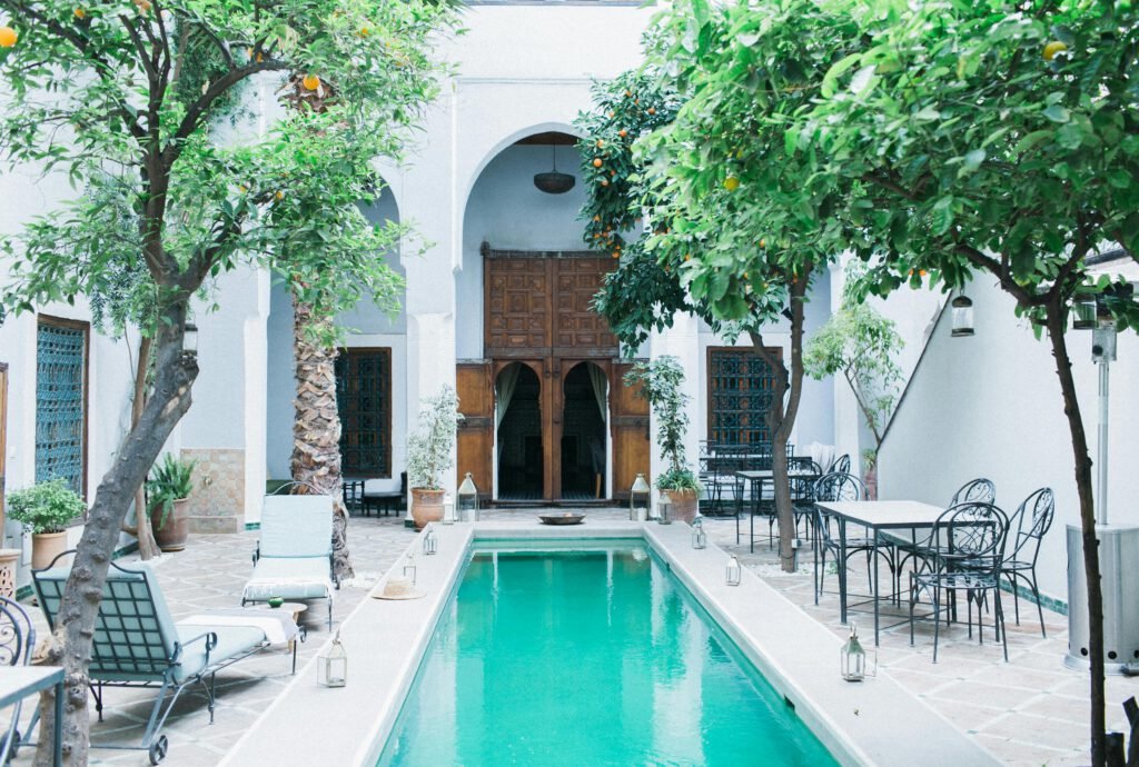 pexels photo 5029310 5029310 Exterior of patio with wooden doorway and tangerine trees near swimming pool and furniture